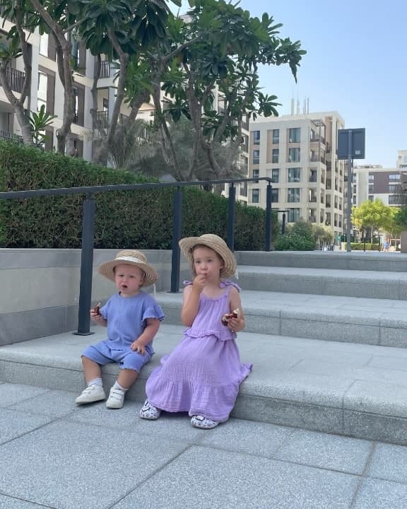 Two sisters on the steps of the Creek Beach inner courtyard, snacking in the shade